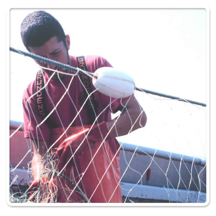 Rama Geroux, a crew member of a salmon fishing vessel, removing salmon from a gillnet in Bristol Bay (� Karen Ducey, NMFS, NOAA Images).
